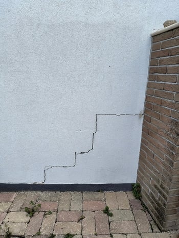 Grietas en forma de escalera en la fachada